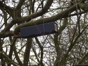 A small black box (2 by 2 inches and about a foot long). One end is closed and the other end has a small woodern lip.